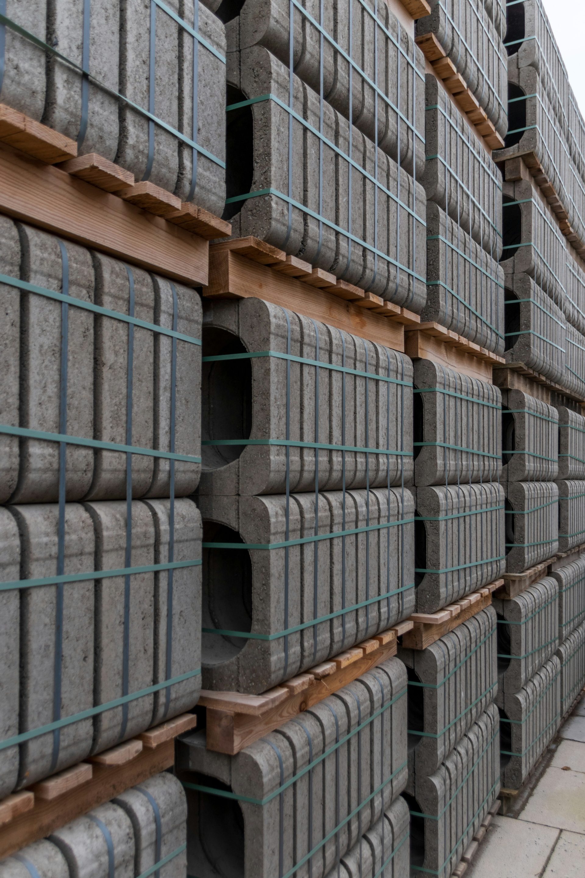 Stacks of gray concrete curbs on wooden pallets