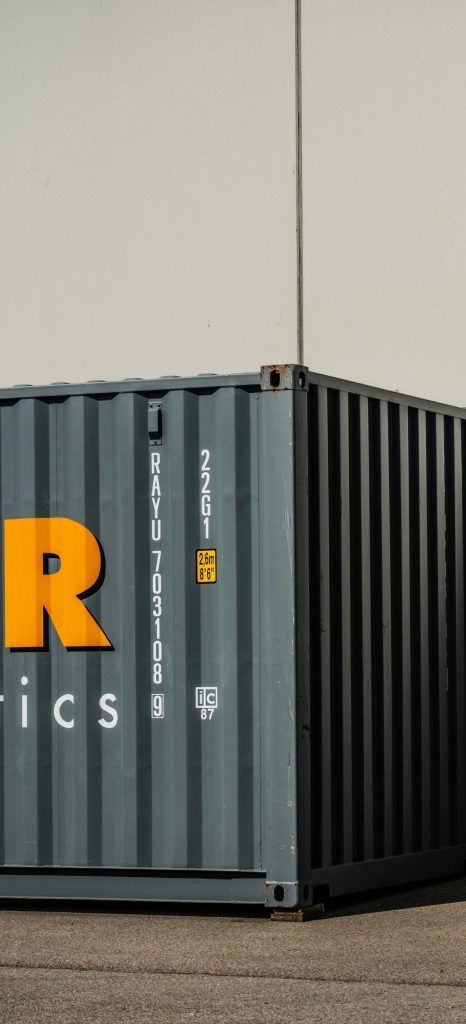 Contenedor de acero negro junto a una pared blanca